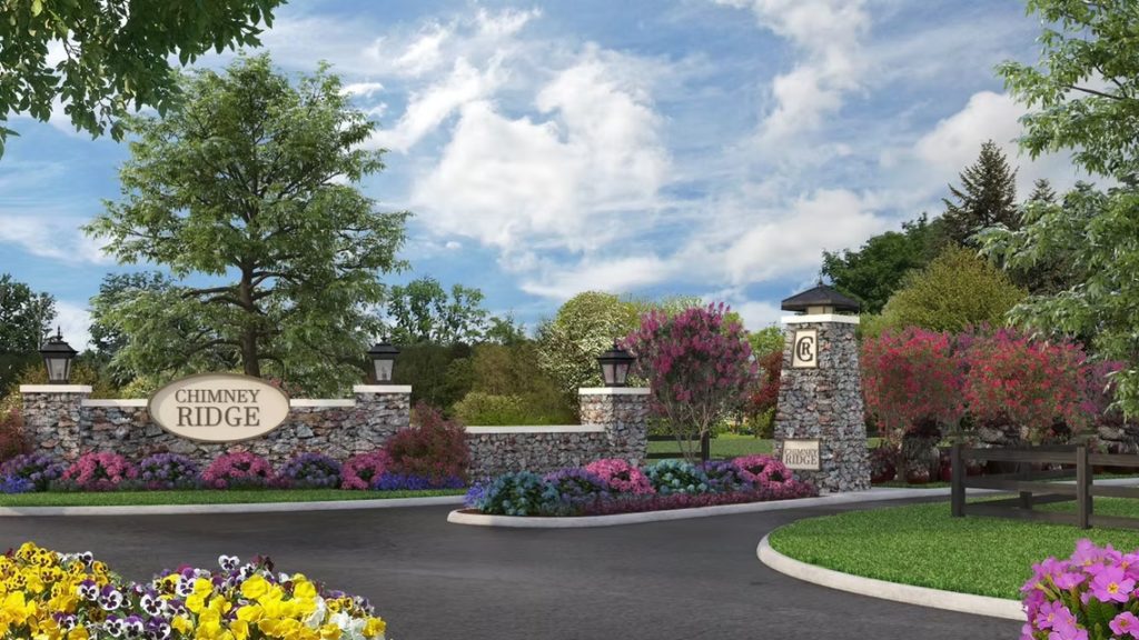 Entrance to ChimneyRidge in Loveland, OH, with Justin Doyle Homes custom home lots available, featuring landscaped streets and a welcoming community sign.